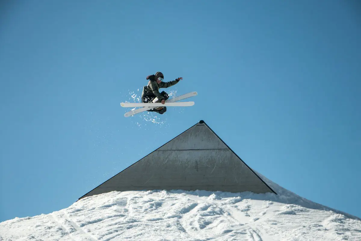 Snowboarder soaring through the air on a jump at the Laax ski resort in Switzerland. Photo by Laurent Perren from Unsplash